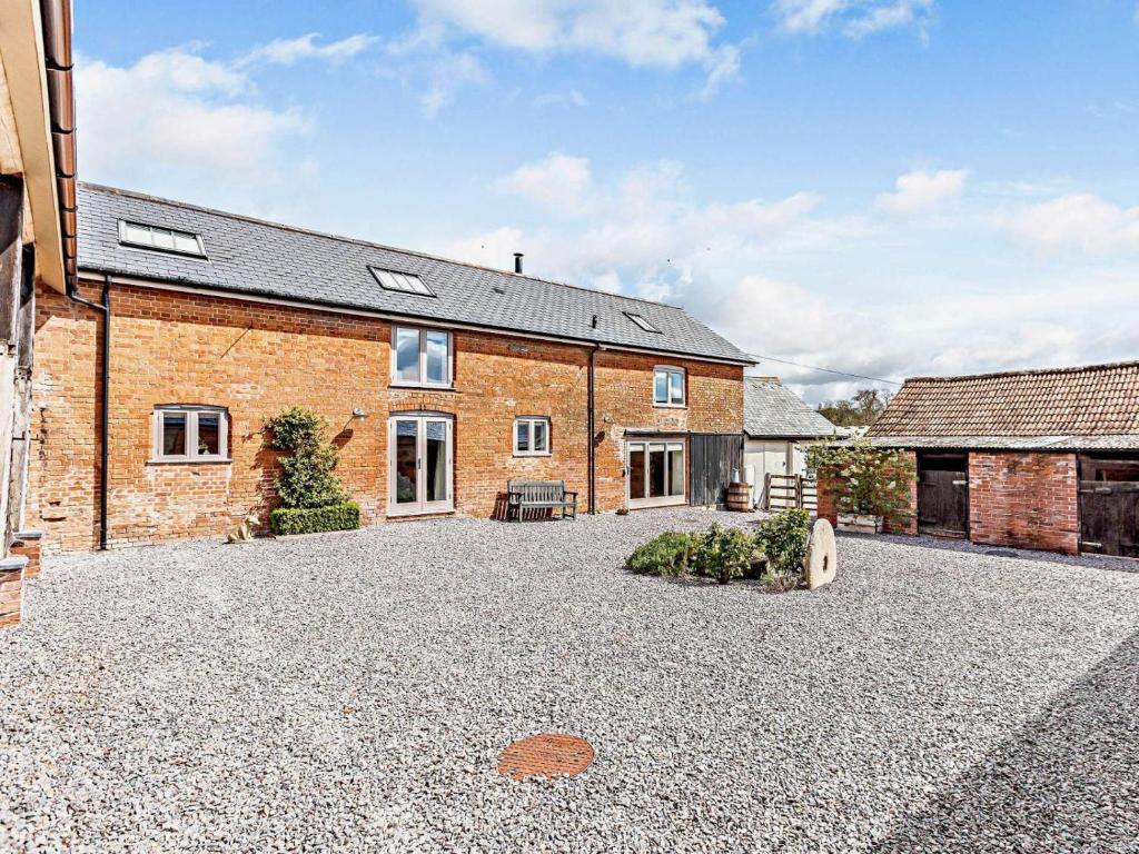 a brick house with a gravel driveway in front of it at 4 Bed in Honiton oc-45563 in Payhembury
