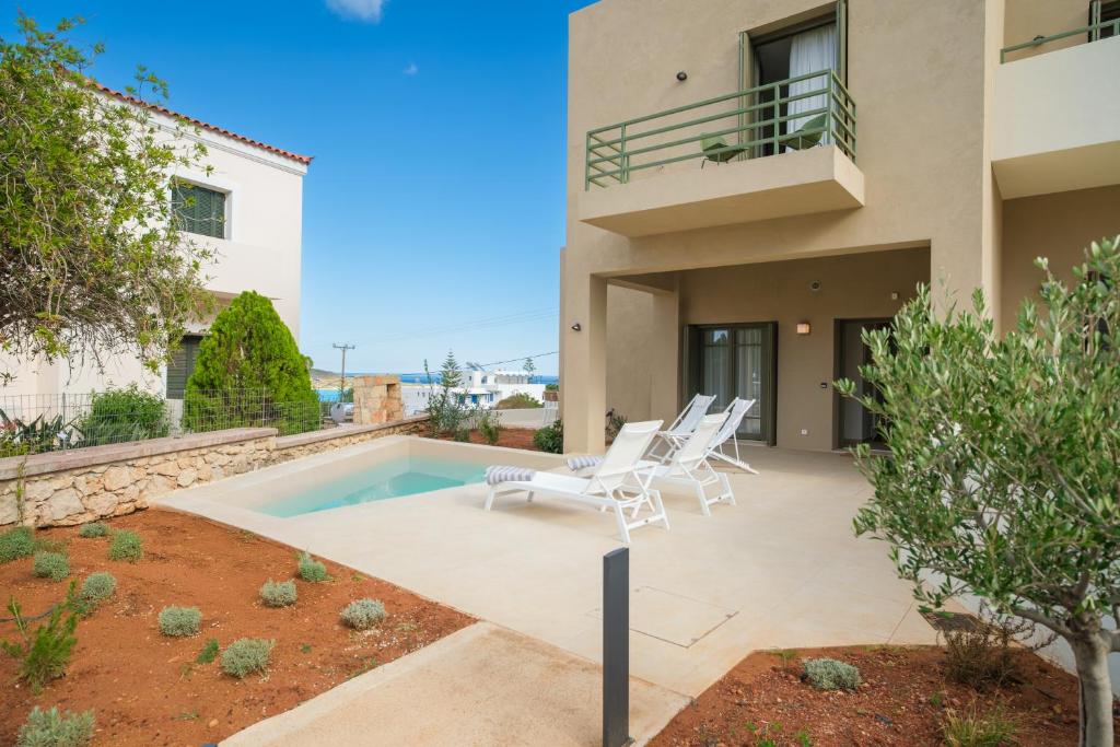 a patio with two chairs and a swimming pool at Villa Artemis 5 - Etheras Properties in Kythira
