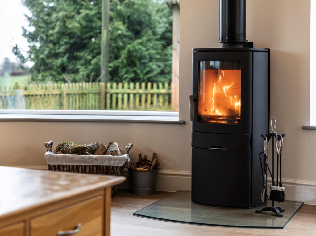 a kitchen with a stove with a fire in it at 5 Bed in Barnstaple oc-85165 in Charles