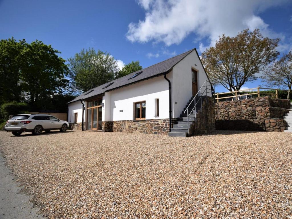 a white house with a car parked in front of it at 2 Bed in Kings Nympton oc-87985 in Kings Nympton