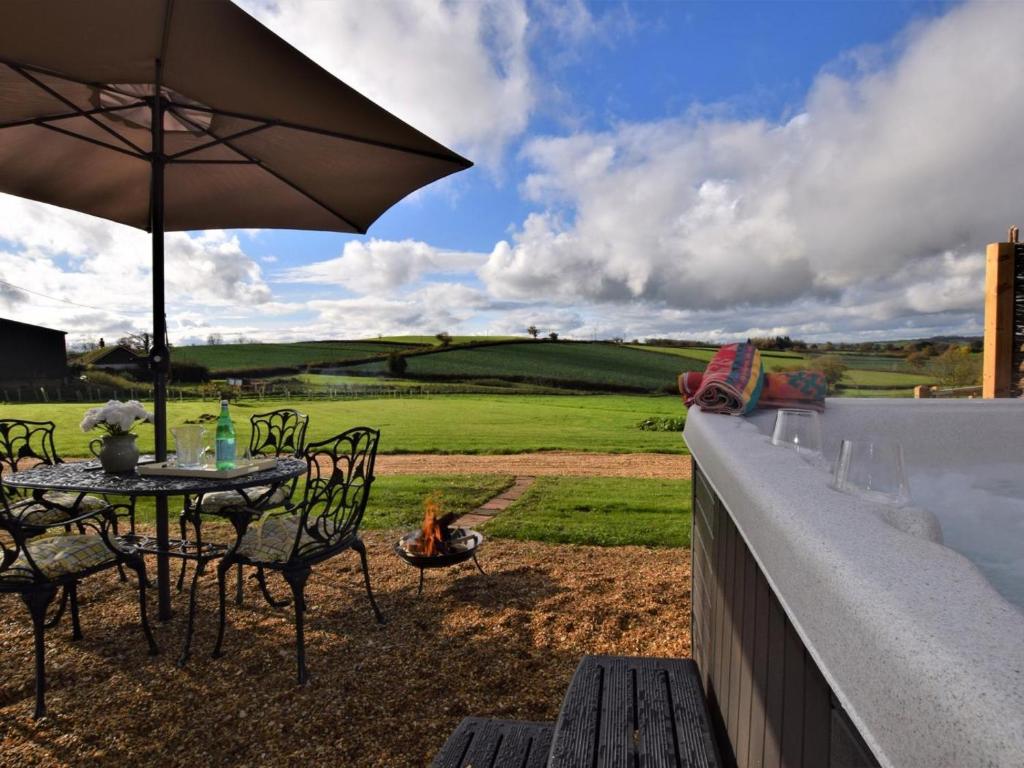 a patio with a table and chairs and an umbrella at 2 Bed in Crediton oc-78468 in Cheriton Fitzpaine