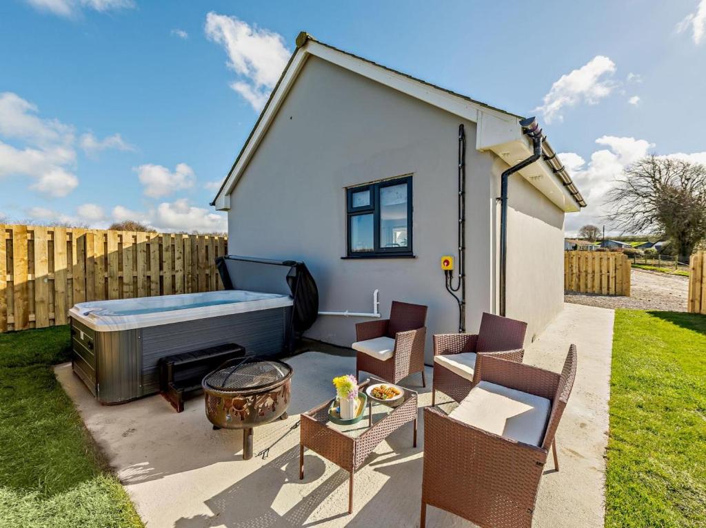 a small backyard with a hot tub and chairs at 1 Bed in Barnstaple oc-91387 in Marwood