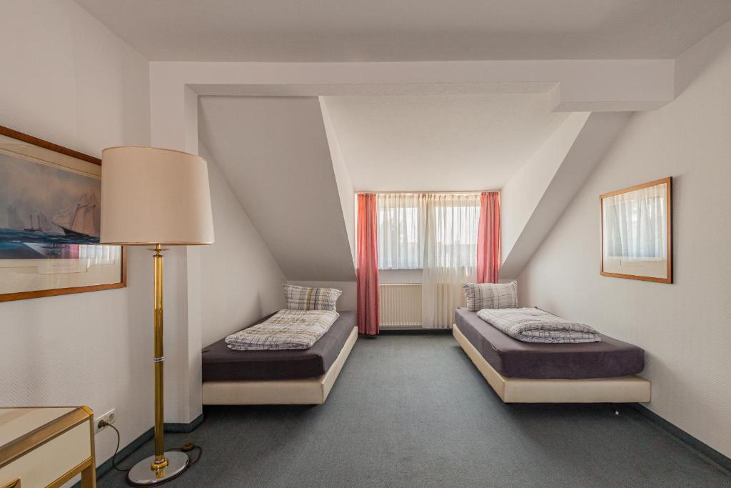 a attic room with two beds and a lamp at Hotel für Monteure in Dresden, Zimmer mit eigenem Bad und großer Gemeinschaftsküche in Dresden