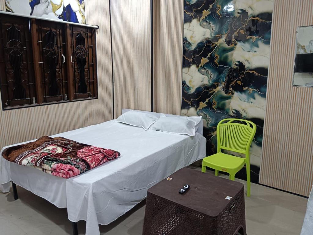 a bedroom with a bed and a green chair at HOTEL Welcome in Jāmb