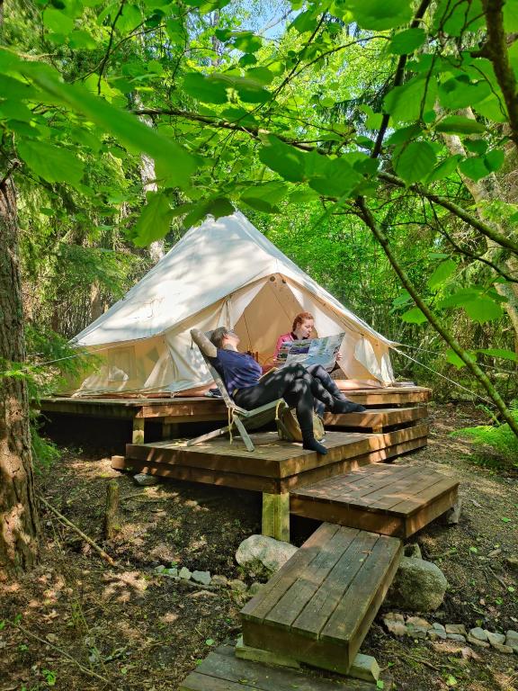 two people sitting in a tent in the woods at Naawa Nature Camp in Korppoo