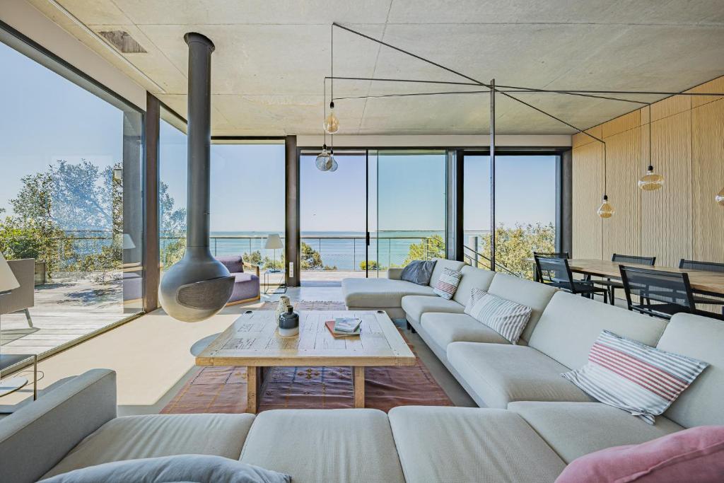 a living room with a large couch and a table at Villa Ciel, vue mer in Pyla-sur-Mer