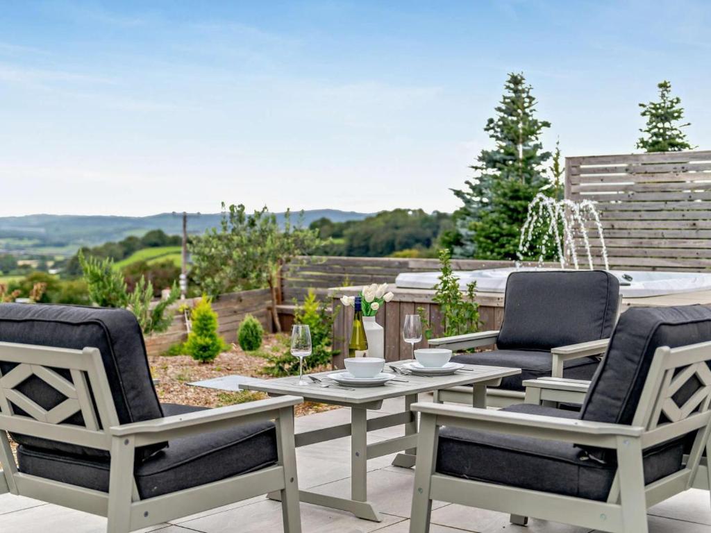 a patio with three chairs and a table on a patio at 1 Bed in Paignton oc-93061 in Marldon