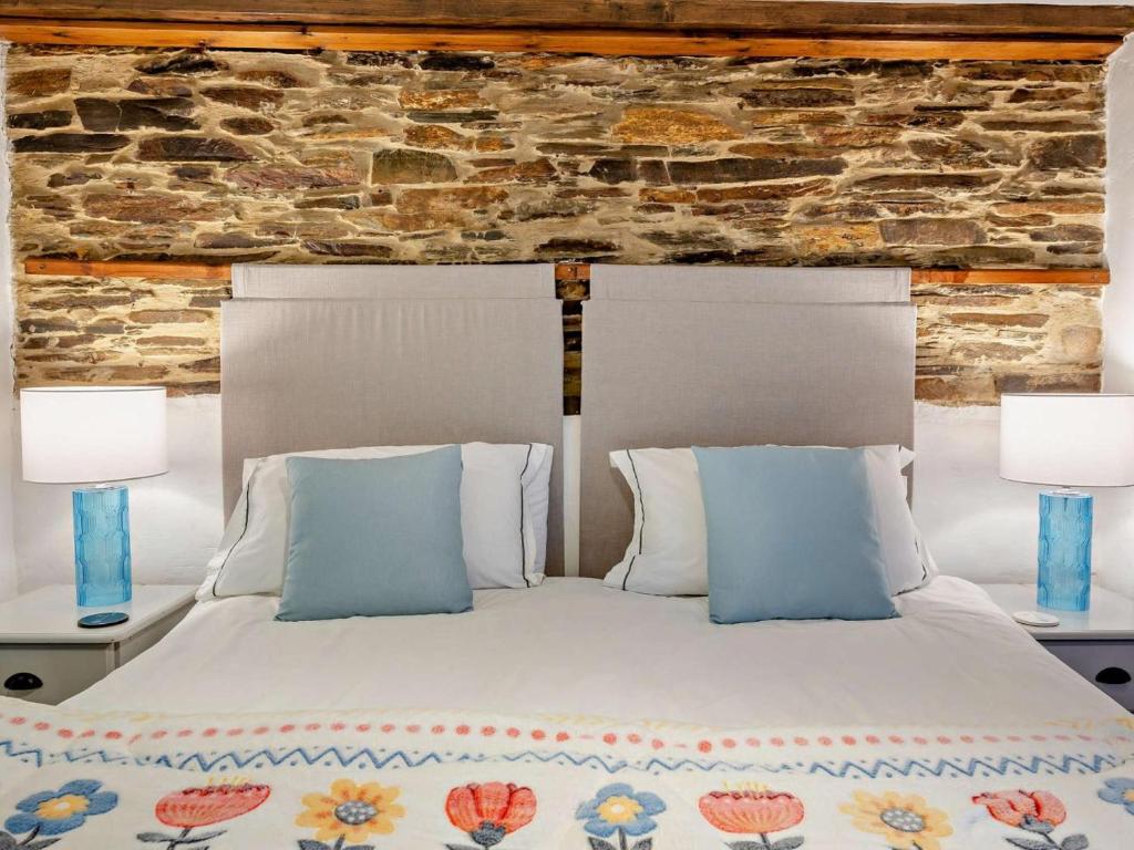 a bedroom with a white bed with two lamps at 1 Bed in Yelverton oc-93333 in Yelverton