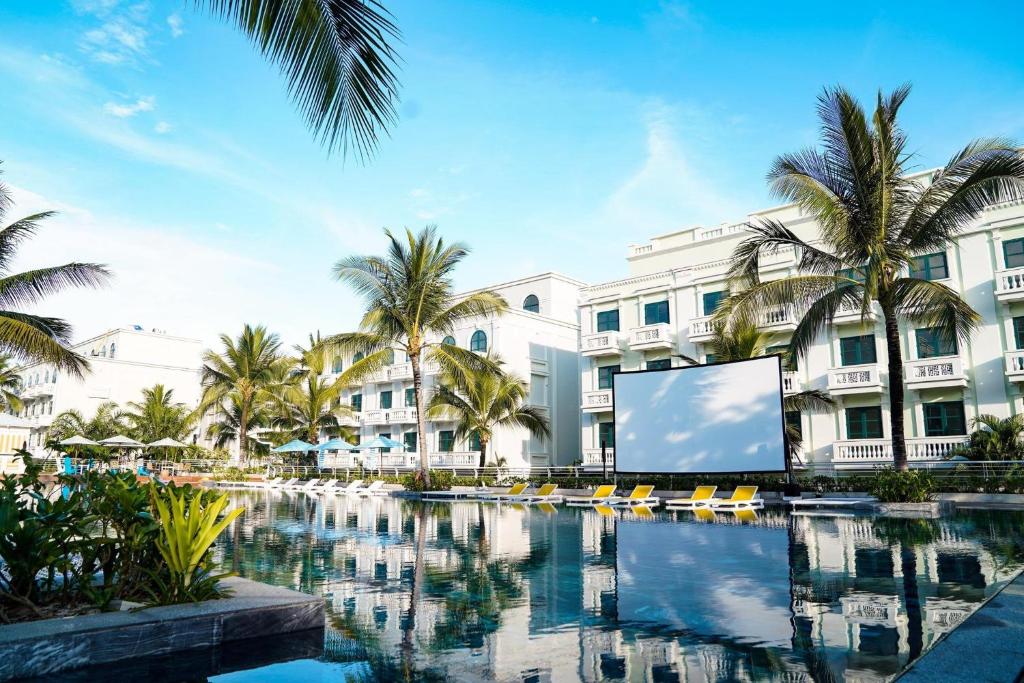 a large building with a large screen in front of a pool at The Happy Marina Hotel Phú Quốc - Sunset & Ocean View in Phú Quốc