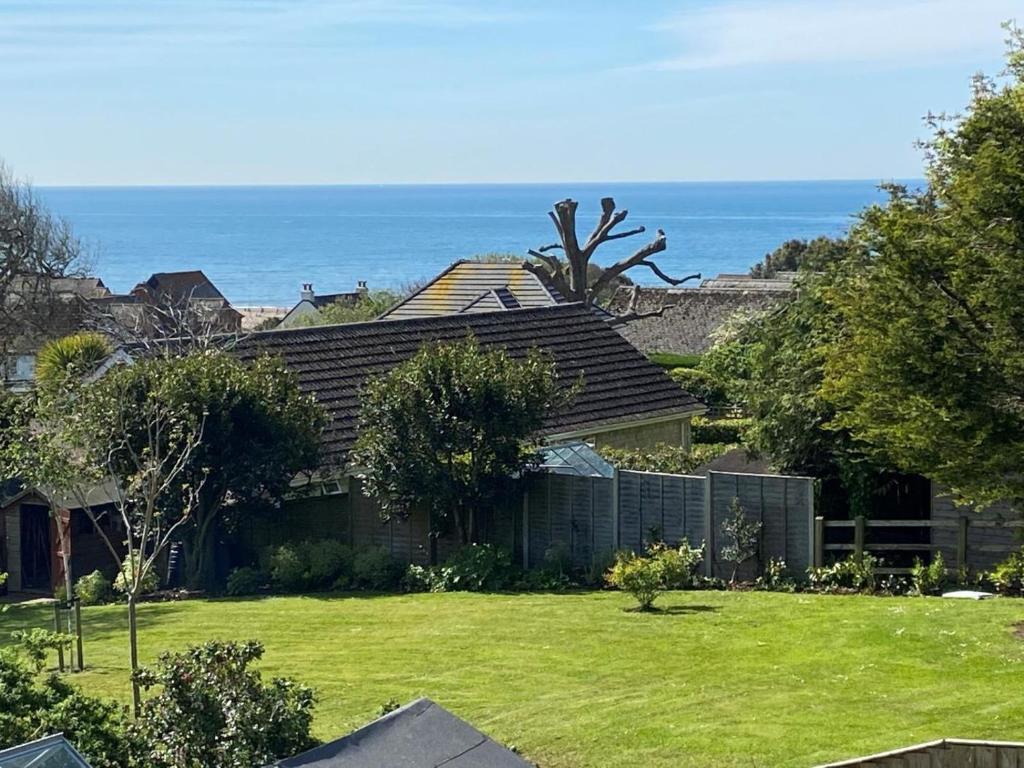 a house with a yard with the ocean in the background at 5 Bed in Bridport oc-83584 in Charmouth