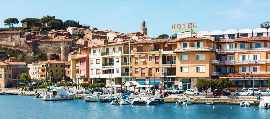 a group of boats docked in a marina with buildings at Hotel L'Approdo in Castiglione della Pescaia