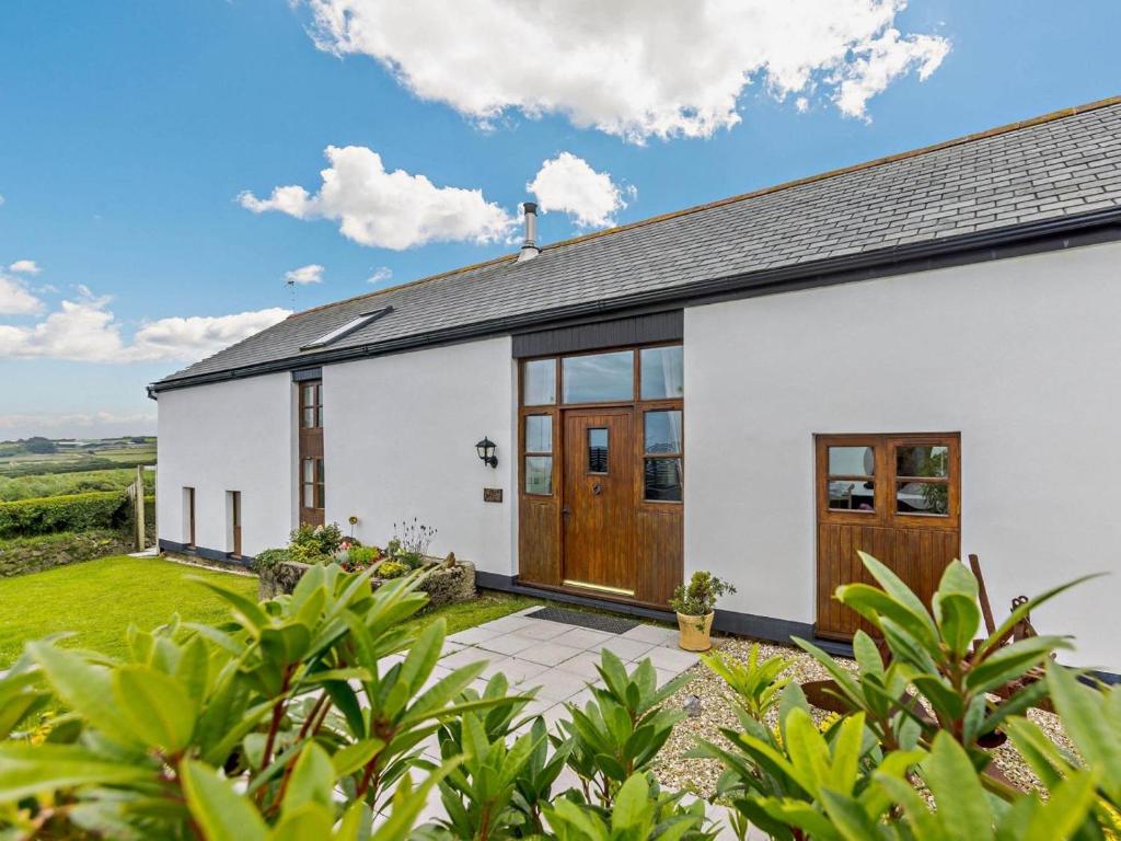 a white house with wooden doors and a yard at 4 Bed in Bideford oc-owlbr in Clovelly