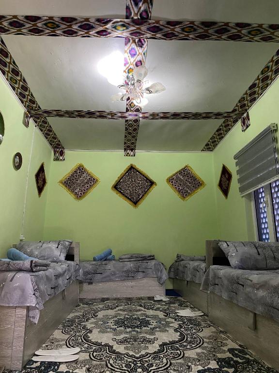 a room with green walls and a ceiling at Guest house Lovely Guest in Bukhara
