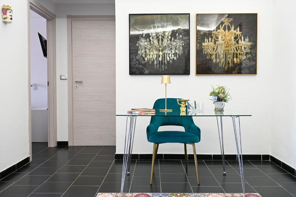 a dining room with a table and a blue chair at GIKLA MAISON in Catania