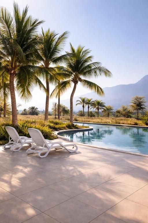 two chairs and palm trees next to a swimming pool at Family Floatie Flat with Pool & Workspace in As Sīfah