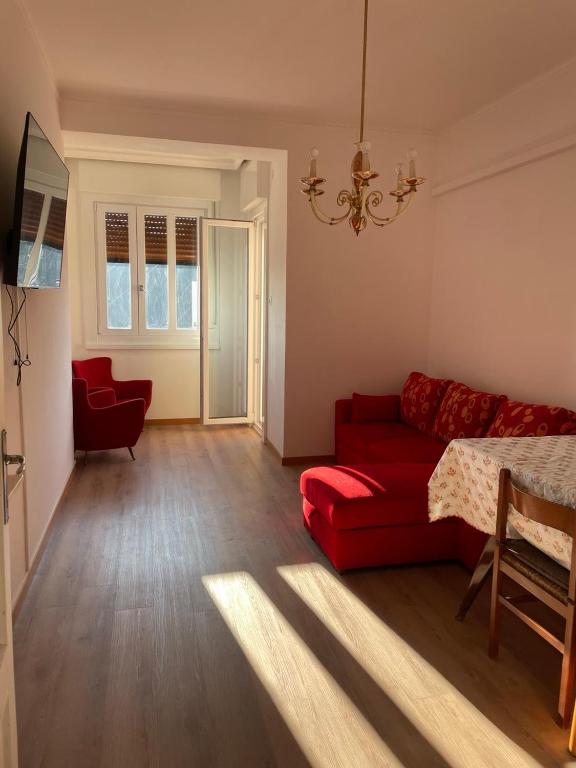 a living room with a red couch and a bed at Casa Nora in Trieste