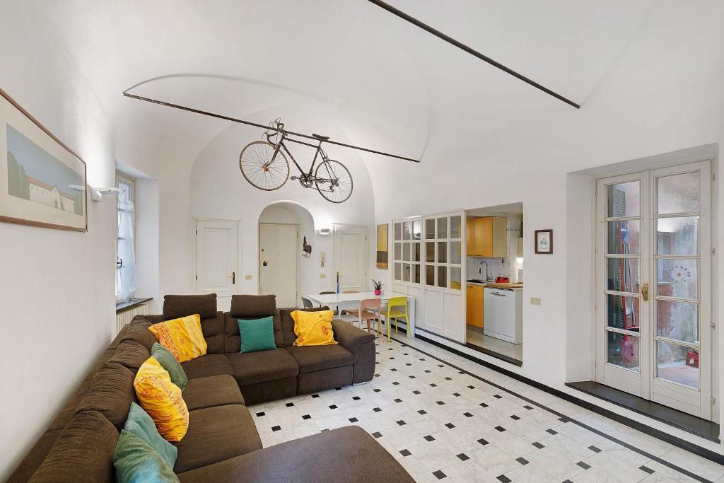 a living room with a couch and a bike hanging from a ceiling at Casa Meloria in Finale Ligure