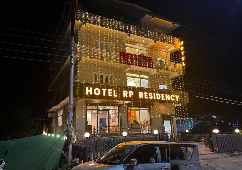 a building with a hotel rep residence with a car in front at Hotel RP Residency in Nakraunda
