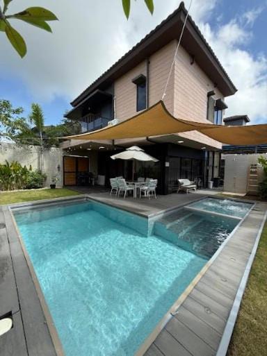 a house with a swimming pool in front of a house at Luxury Villa by Andres in San Juan