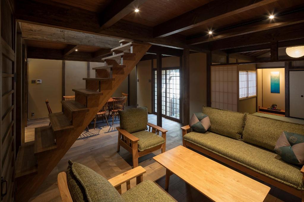 a living room with a couch and a staircase at Choya Goshominami Machiya House in Kyoto