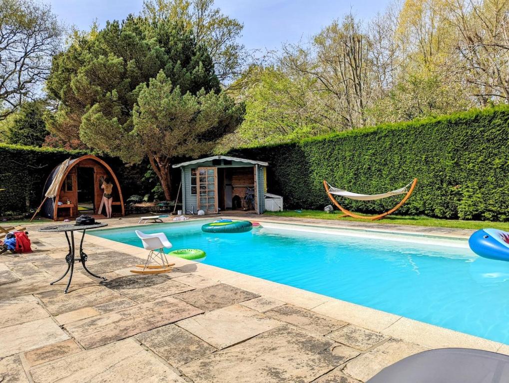 a swimming pool with a hammock in a yard at Woodside Studio in Hassocks