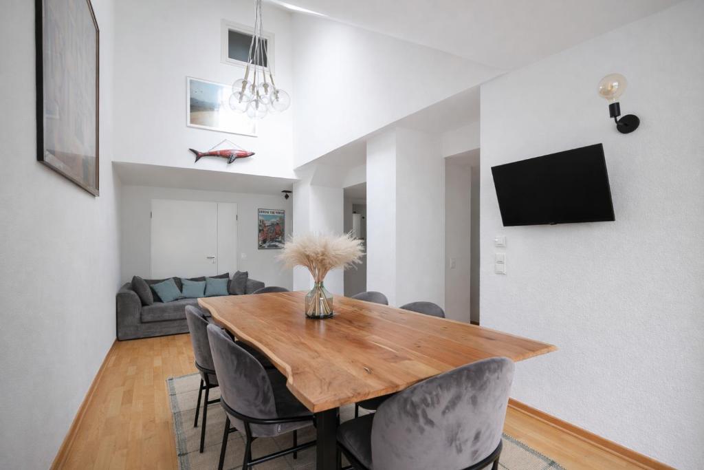 a dining room with a wooden table and chairs at Design Apartments - "Potsdam City" , 19 in Potsdam