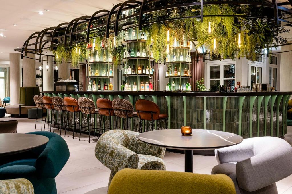 a restaurant with tables and chairs and a bar at Motel One Frankfurt-Hauptbahnhof in Frankfurt
