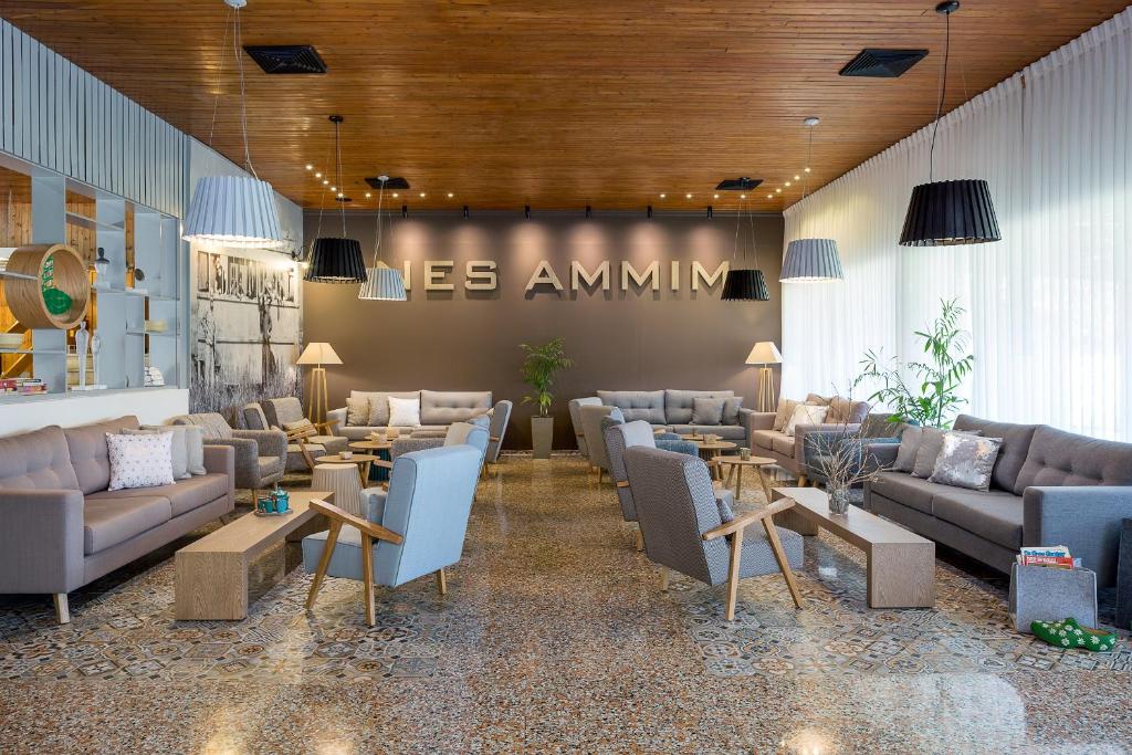 a waiting room with couches and tables in a lobby at Nes Ammim Hotel in Nes Ammim