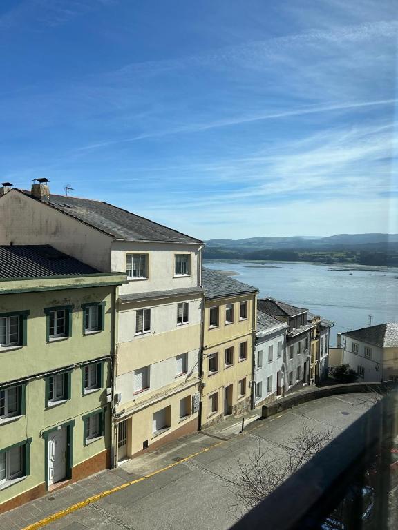 a city street with buildings and a view of the water at Piso Ría de Ribadeo in Ribadeo