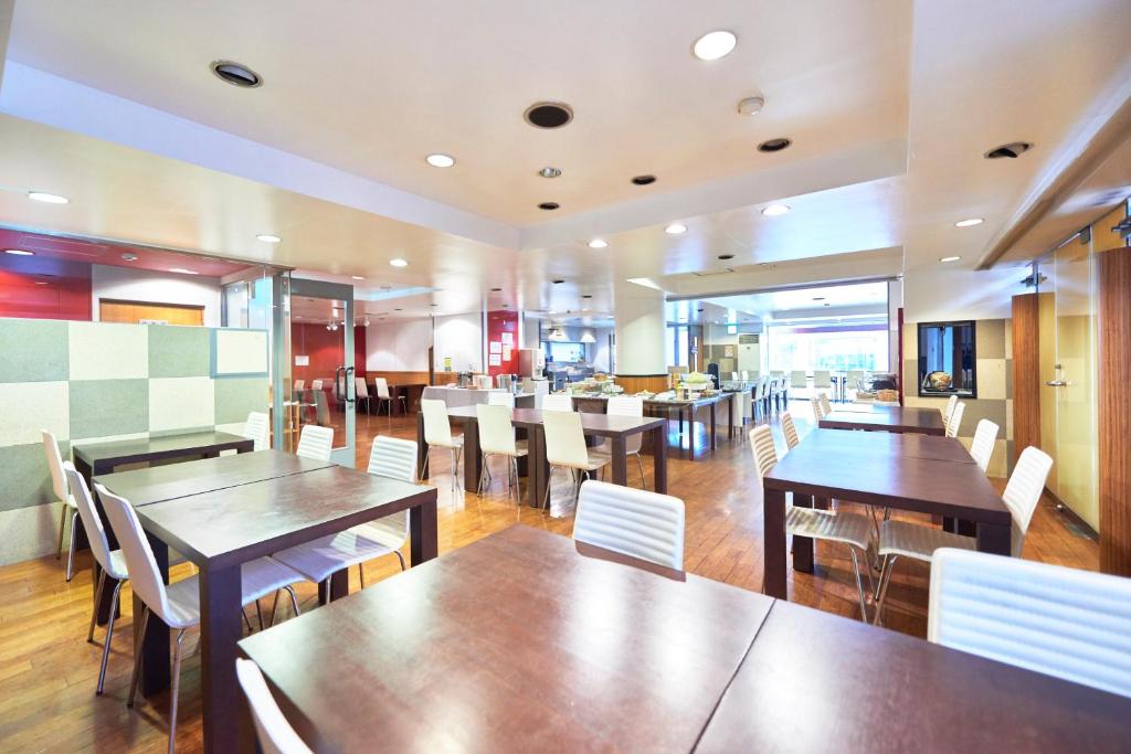 a restaurant with wooden tables and white chairs at Select Inn Fujisan Gotemba in Gotemba
