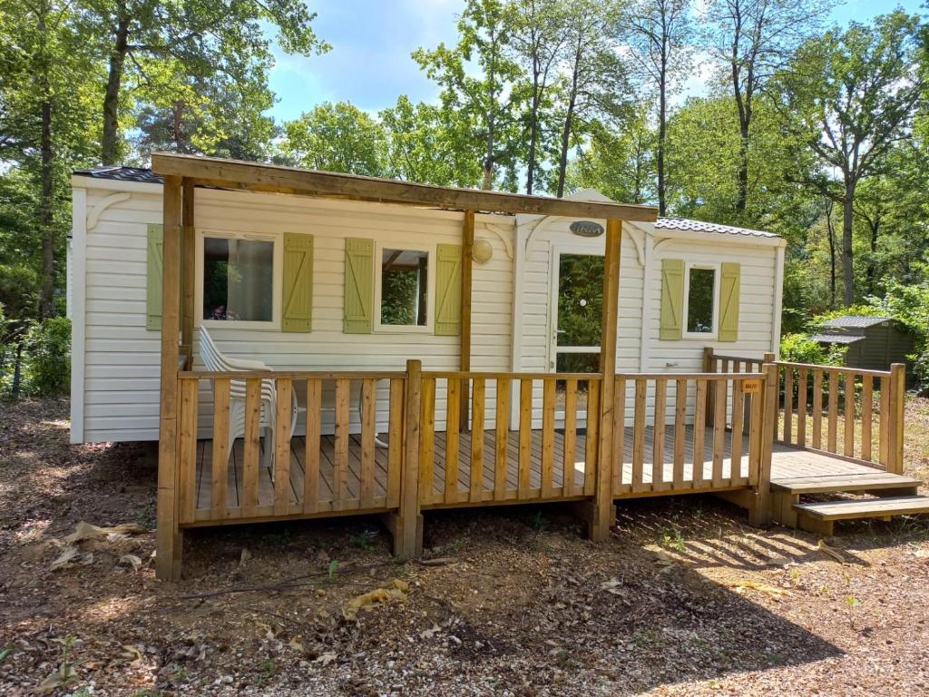 a tiny house with a porch and a deck at Mobil-House Parc des Roches in Saint-Chéron