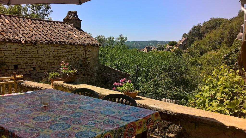 a table and chairs on a patio with a view at Gîte de Bontemps in Saint-Vincent-de-Cosse
