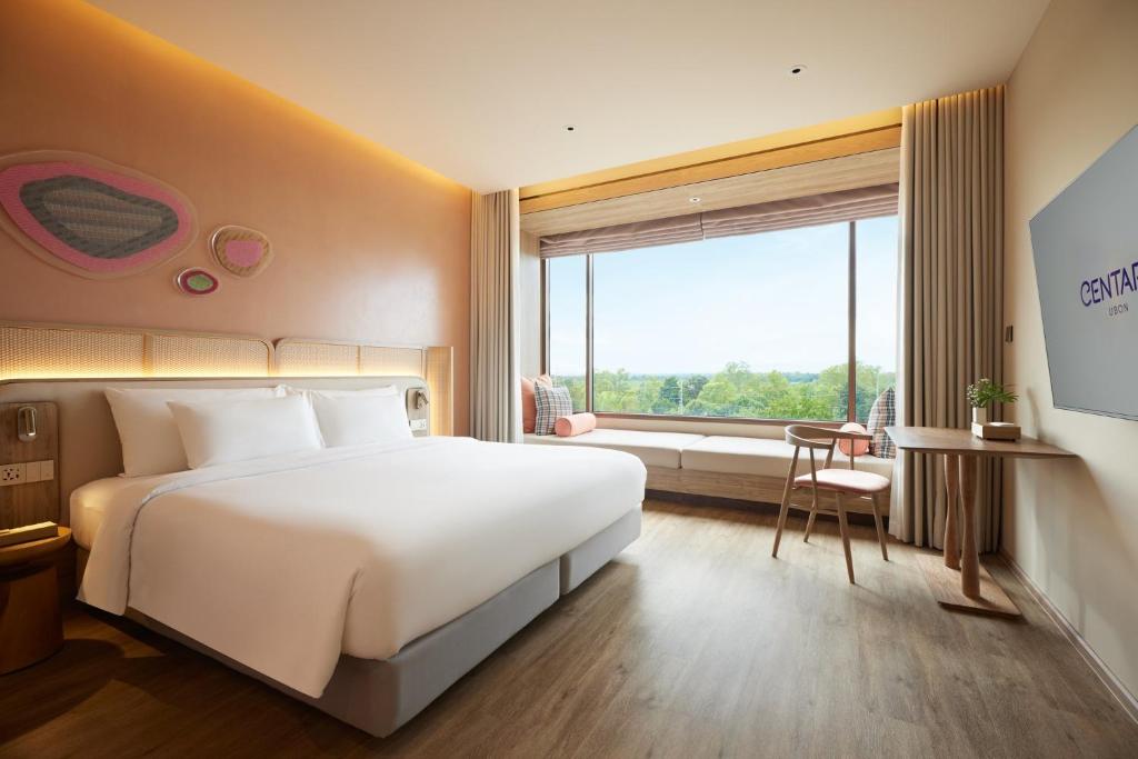 a hotel room with a large bed and a window at Centara Ubon in Ubon Ratchathani