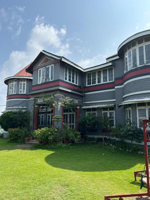 a large house with a lawn in front of it at Solan Retreat in Solan