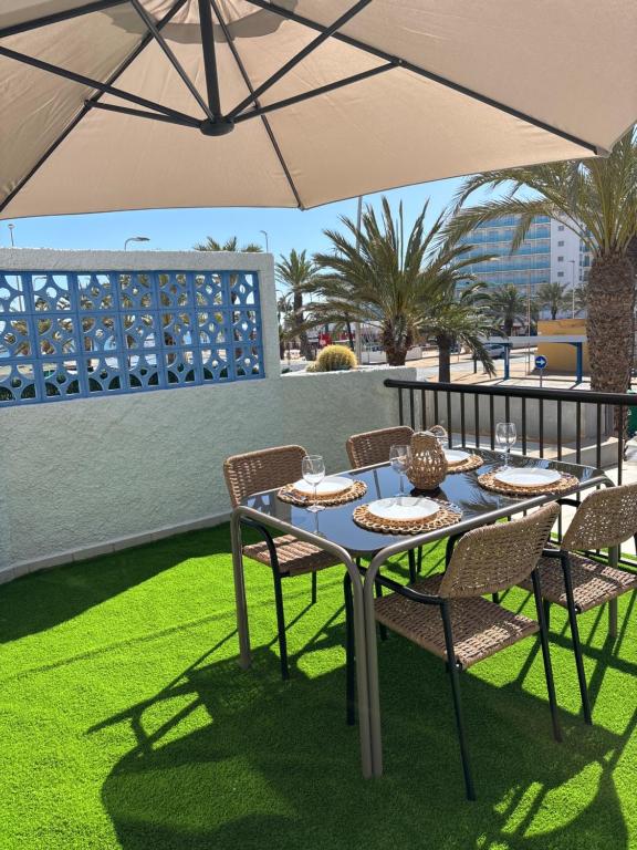 a table with chairs and an umbrella on a patio at Isabella in Roquetas de Mar