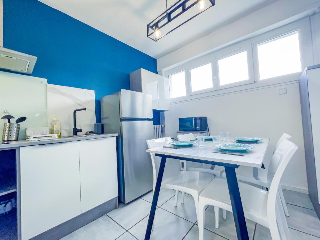 a kitchen with a table and a refrigerator at Bel appartement à Royat in Royat