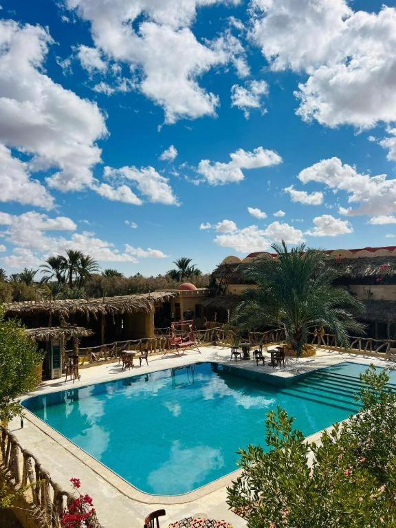 a large blue swimming pool in a resort at Aghurmi Siwa Hotel in Siwa