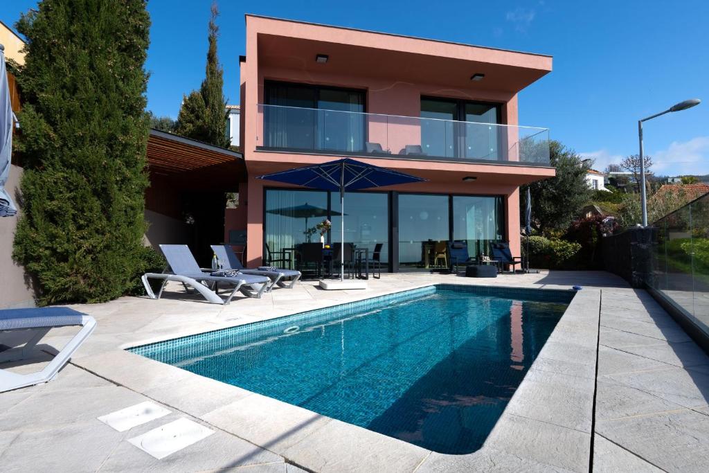 a house with a swimming pool in front of a house at Elísio do Mar by LovelyStay in Prazeres