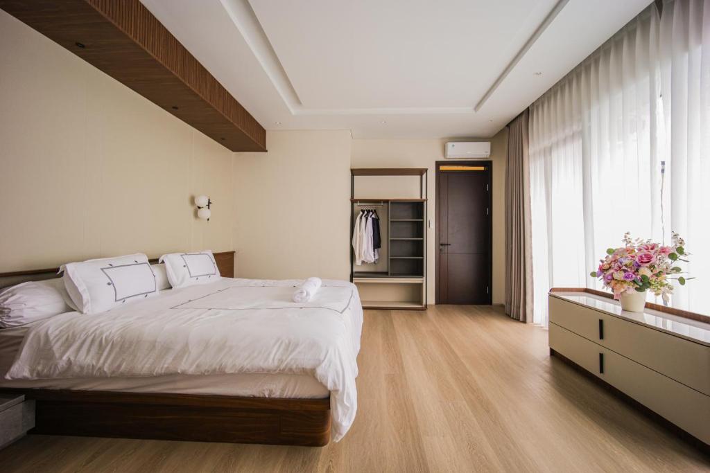 a bedroom with a large bed and a large window at Casa Miera in Bandung