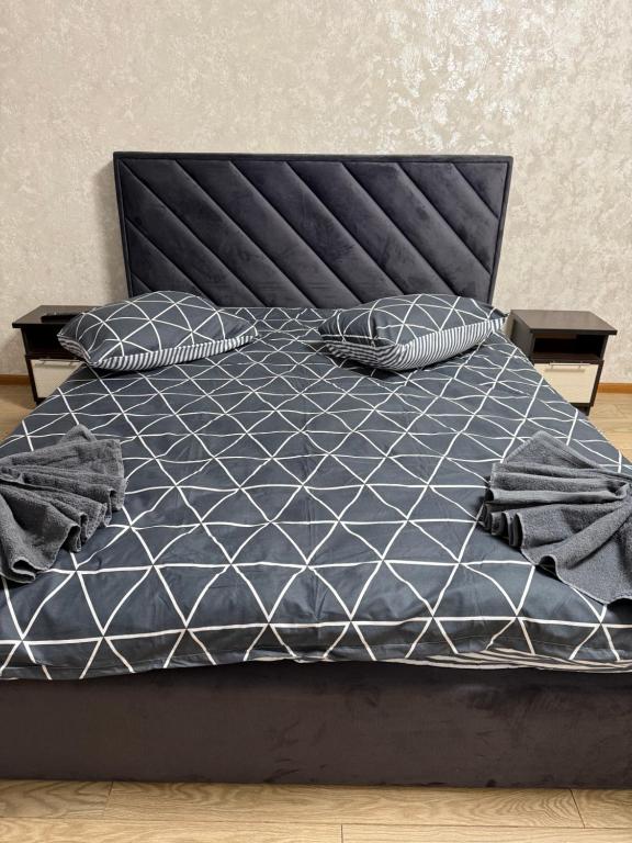 a bed with a blue comforter and pillows on it at Апартамент с джакузи in Khmelnytskyi
