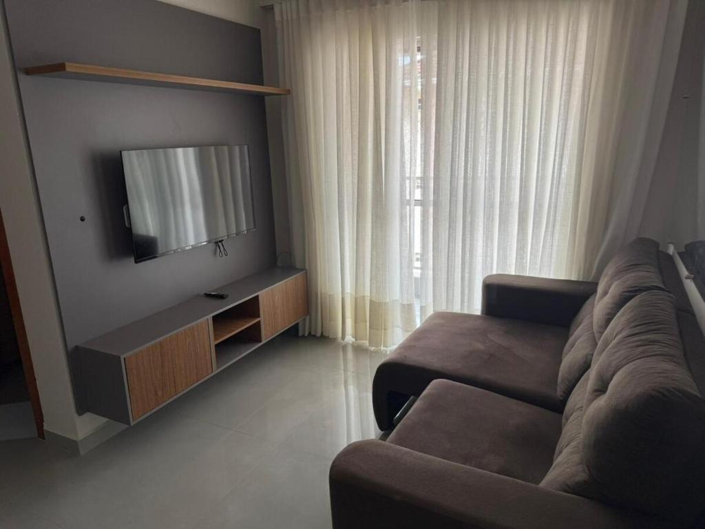 a living room with a couch and a flat screen tv at Apartamento confortável in Santarém