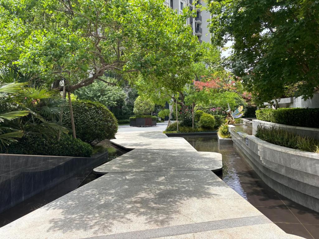 a walkway next to a river with trees at 春江屿舍 in Xi'an
