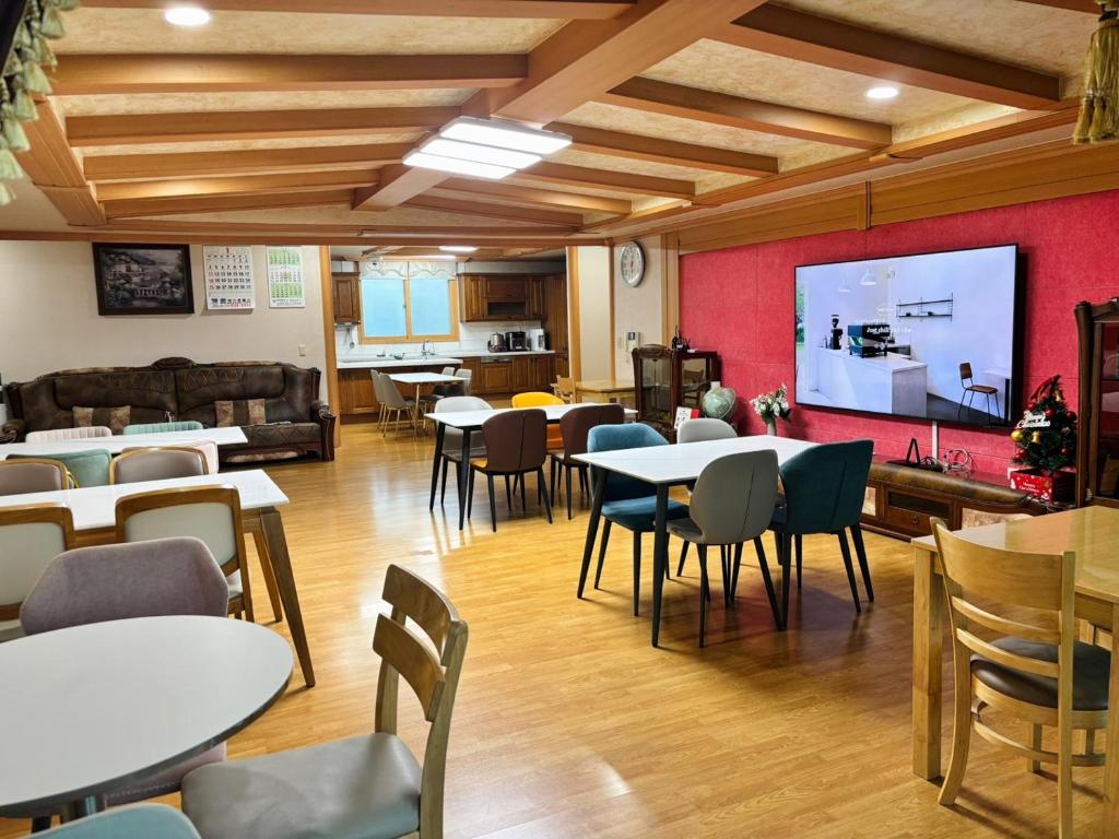 a room with tables and chairs and a projection screen at 파노라마 스테이 in Paranjang