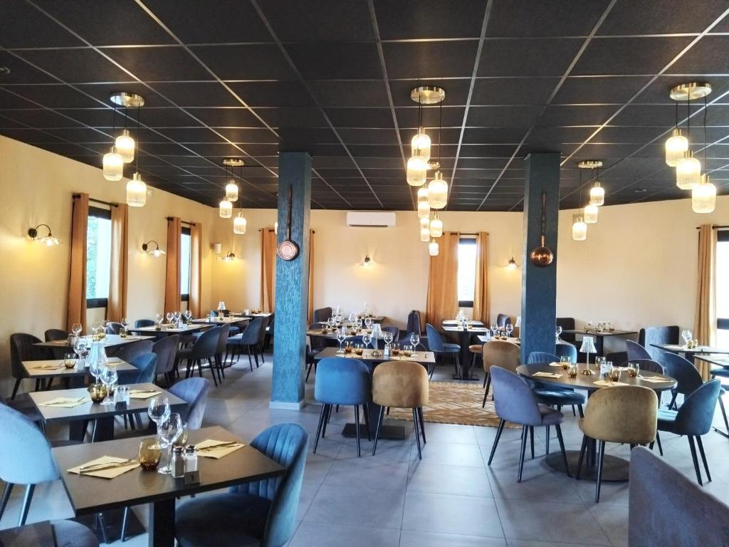 a dining room with tables and chairs at Hôtel Le Bratoria, anciennement Le Saint Vincent in Vourles