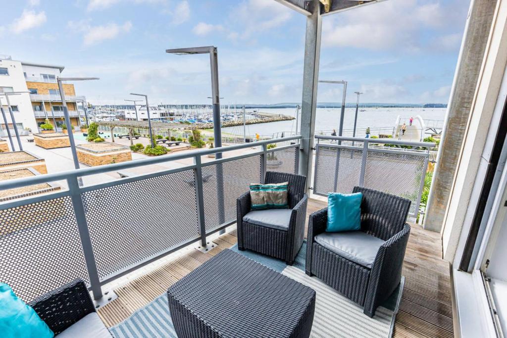 a balcony with chairs and a view of the ocean at Harbourside Retreat - Spacious Balcony with Harbour Views in Poole
