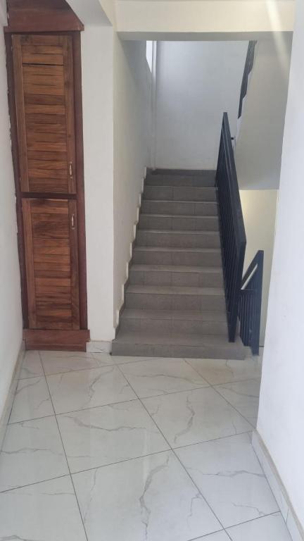 a hallway with a staircase with a wooden door at Résidence PAYAN in Douala