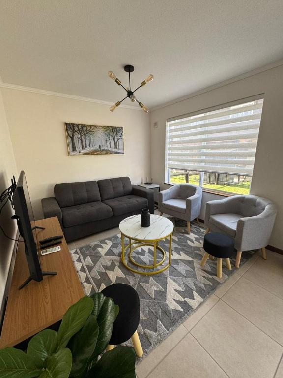 a living room with a couch and a table at Pucon, casa condominio in Pucón