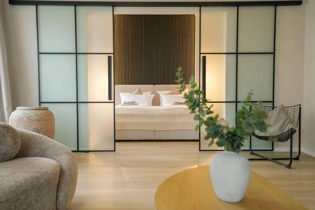 a living room with a bed and a vase on a table at Boutique Hotel an der Mosel - ehemalig Hotel Kreuter in Koblenz