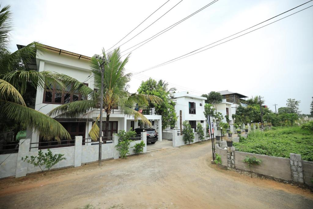 a house with a palm tree in front of it at Ashiyana Homes in Nedumbassery