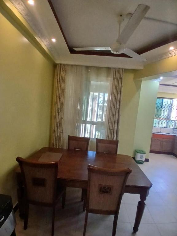 a dining room with a wooden table and chairs at Kariba 8 in Mombasa